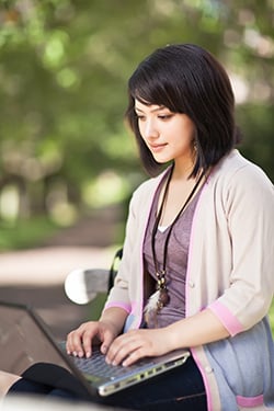 you woman on laptop in park