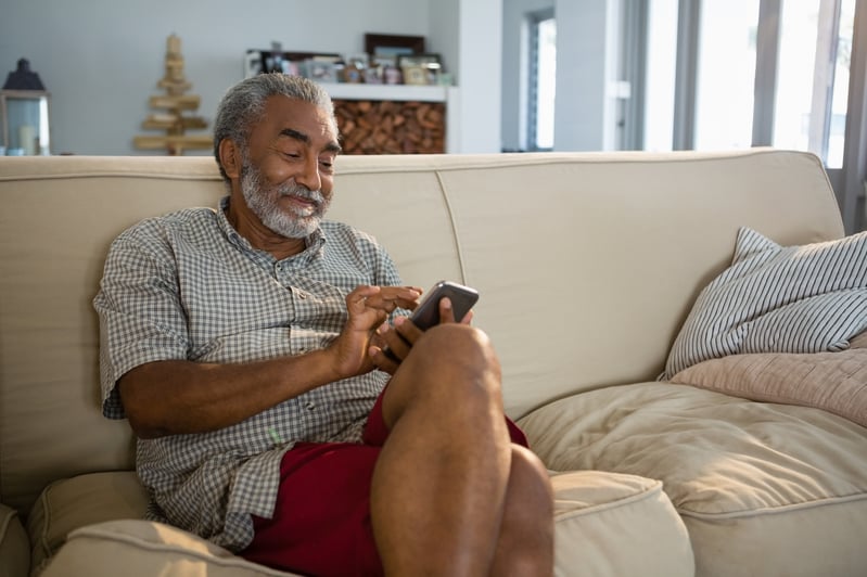 A person sitting on a couch using a phone.