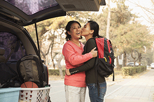 college student kissing mom goodbye